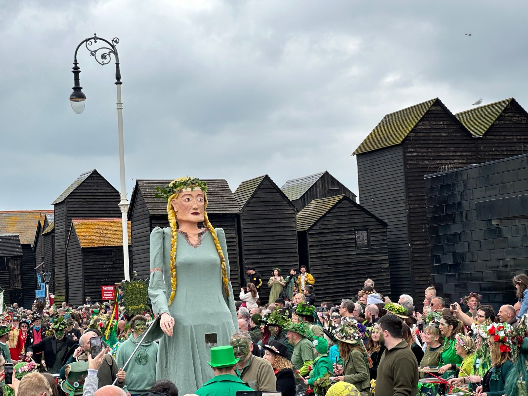 The net shops on the Stade during Jack in the Green, a giant garlanded figure above the crowd